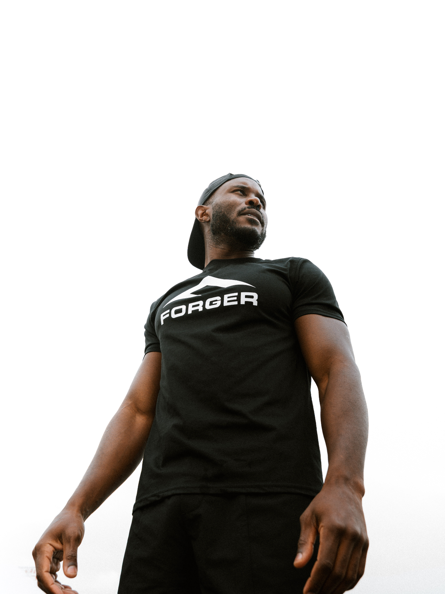 Portrait de Junior Tanzey, fondateur FORGER, t-shirt logo et casquette.